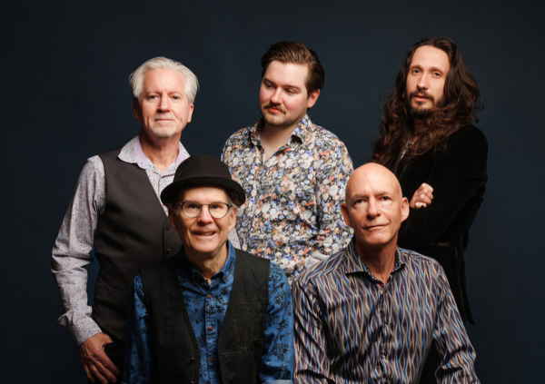 Five piece 70s rock tribute show members posing together in front of gray backdrop | Altus Entertainment